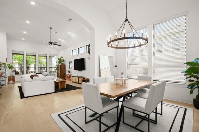 1244 Calendula Trl, Georgetown, TX 78628 - dining area with arched walkways, light wood-style floors, a chandelier, recessed lighting, and high vaulted ceiling