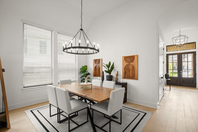 1244 Calendula Trl, Georgetown, TX 78628 - dining space with a chandelier, french doors, light wood-style floors, baseboards, and high vaulted ceiling