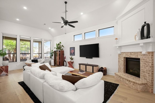 1244 Calendula Trl, Georgetown, TX 78628 - living area featuring light wood finished floors, a ceiling fan, recessed lighting, a brick fireplace, and baseboards