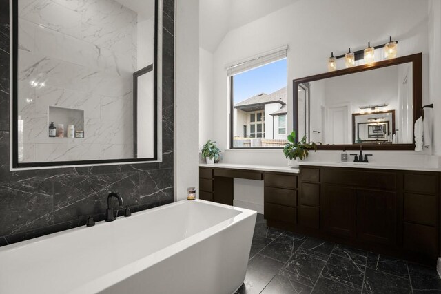 1244 Calendula Trl, Georgetown, TX 78628 - full bath featuring a soaking tub, vaulted ceiling, marble look tiles, and vanity