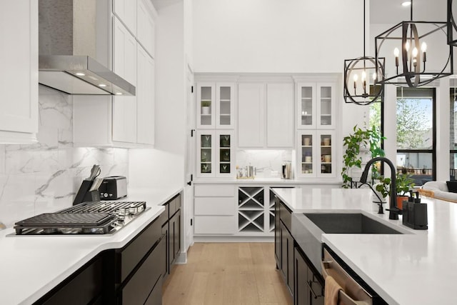 1244 Calendula Trl, Georgetown, TX 78628 - kitchen with wall chimney exhaust hood, a sink, a chandelier, light countertops, and a high ceiling