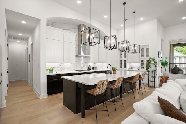 1244 Calendula Trl, Georgetown, TX 78628 - kitchen with wall chimney range hood, a chandelier, open floor plan, light countertops, and a breakfast bar