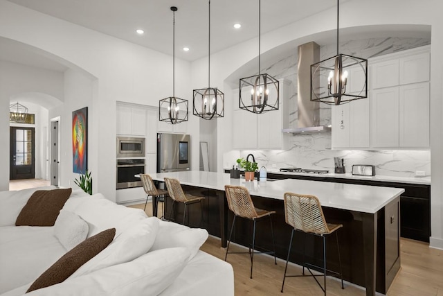1244 Calendula Trl, Georgetown, TX 78628 - kitchen with a chandelier, stainless steel appliances, light countertops, wall chimney range hood, and tasteful backsplash