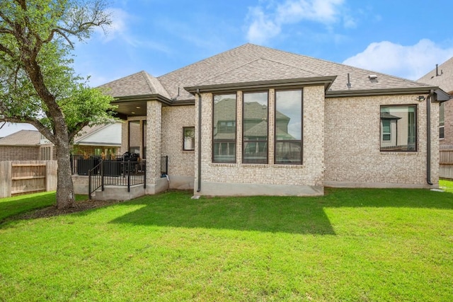 1244 Calendula Trl, Georgetown, TX 78628 - rear view of property featuring a shingled roof, brick siding, and a patio area