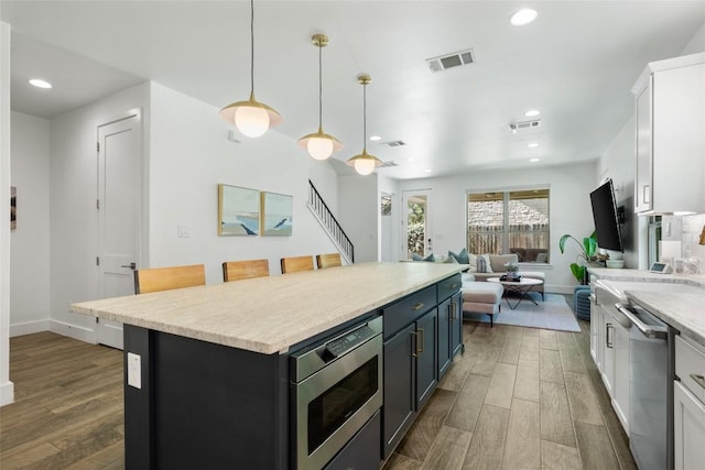 417 Wichita St, Meadowlakes, TX 78654 - kitchen featuring stainless steel appliances, dark wood-style flooring, white cabinetry, light countertops, and recessed lighting