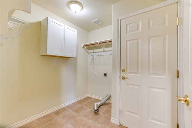 104 Springfield, Horseshoe Bay, TX 78657 - laundry room featuring hookup for an electric dryer, cabinet space, baseboards, and light tile patterned floors