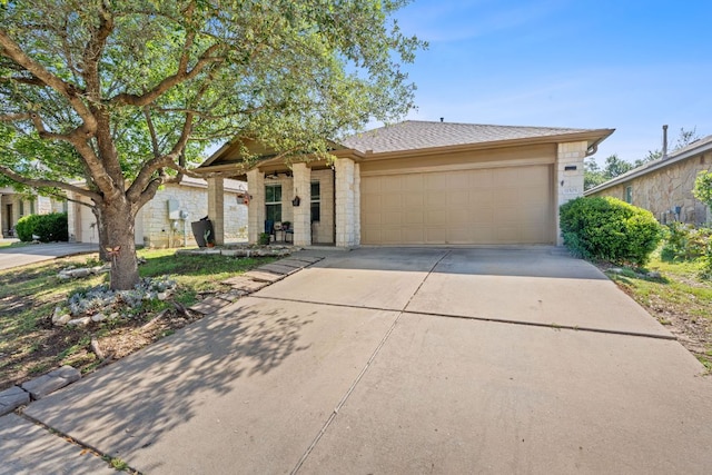 view of front of property with a garage, concrete driveway, stone siding, and a shingled roof