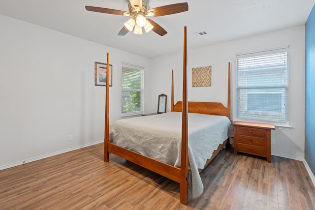bedroom featuring wood finished floors, baseboards, and a ceiling fan