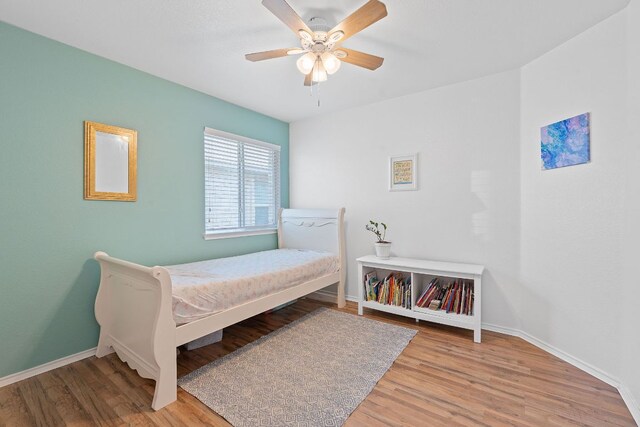 bedroom with wood finished floors, baseboards, and ceiling fan