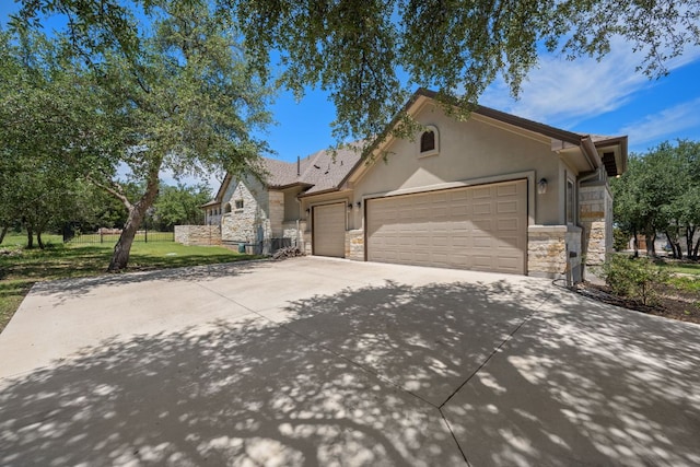 106 Gabriel Woods Dr, Georgetown, TX 78633 - ranch-style home with stone siding, an attached garage, concrete driveway, a front lawn, and stucco siding