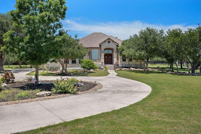 106 Gabriel Woods Dr, Georgetown, TX 78633 - view of front facade with a front lawn, curved driveway, stucco siding, and stone siding