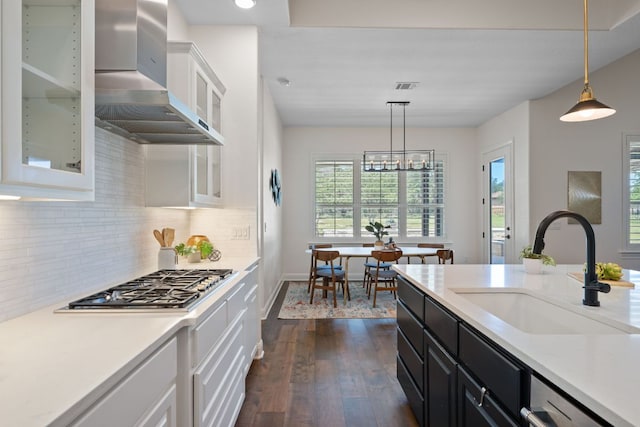 106 Gabriel Woods Dr, Georgetown, TX 78633 - kitchen featuring dark wood finished floors, wall chimney exhaust hood, white cabinetry, dark cabinetry, and light countertops
