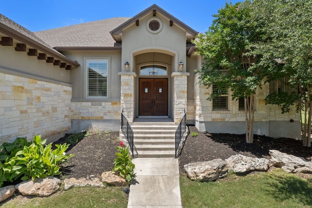106 Gabriel Woods Dr, Georgetown, TX 78633 - view of exterior entry featuring stone siding, stucco siding, and roof with shingles