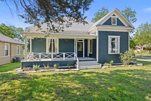 1019 W 4th St, Taylor, TX 76574 - view of front of house with a porch, a front yard, and central AC