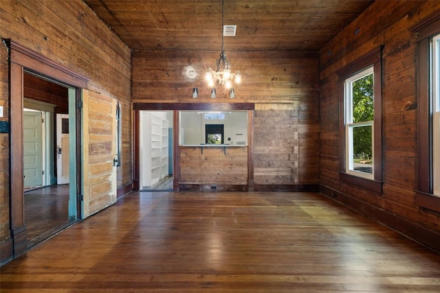 1019 W 4th St, Taylor, TX 76574 - spare room featuring wooden walls, dark wood-type flooring, a chandelier, and wood ceiling