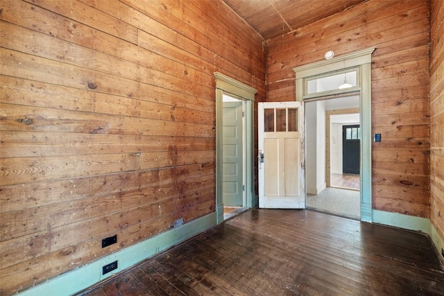 1019 W 4th St, Taylor, TX 76574 - spare room with wood walls, wooden ceiling, dark wood-type flooring, and baseboards