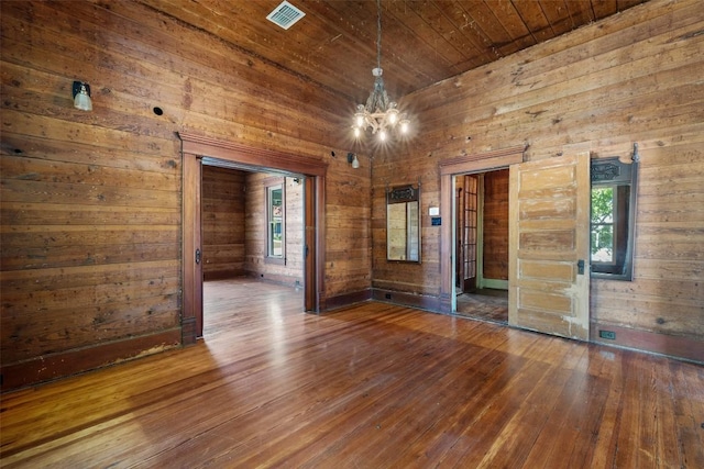 1019 W 4th St, Taylor, TX 76574 - spare room with hardwood / wood-style floors, a chandelier, wooden walls, and wooden ceiling