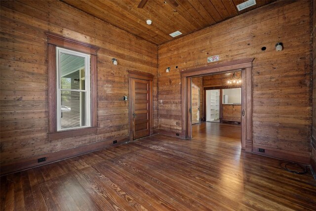 1019 W 4th St, Taylor, TX 76574 - spare room featuring dark wood finished floors, wooden walls, and wood ceiling