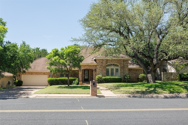10242 Pinehurst Dr, Austin, TX 78747 - view of front of home with a tiled roof, driveway, an attached garage, and a front yard