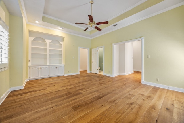 10242 Pinehurst Dr, Austin, TX 78747 - unfurnished bedroom featuring a tray ceiling, light wood-type flooring, crown molding, baseboards, and a ceiling fan