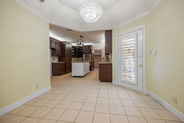 10242 Pinehurst Dr, Austin, TX 78747 - kitchen with stainless steel microwave, backsplash, a chandelier, dark brown cabinets, and light tile patterned flooring