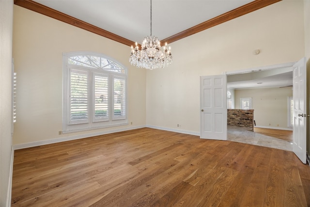 10242 Pinehurst Dr, Austin, TX 78747 - unfurnished room featuring a chandelier, baseboards, light wood finished floors, healthy amount of natural light, and ornamental molding