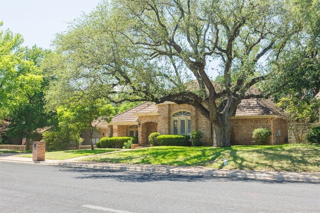 10242 Pinehurst Dr, Austin, TX 78747 - view of front of property featuring brick siding and a front lawn