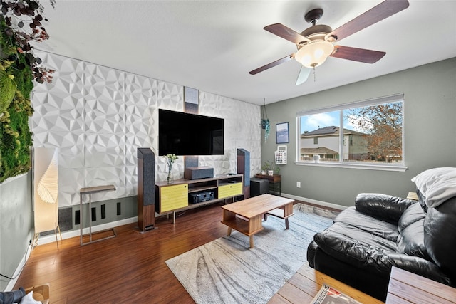 living area with dark wood finished floors, ceiling fan, and baseboards