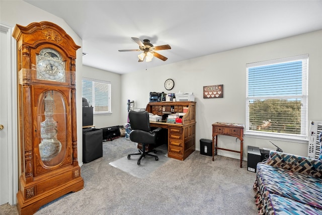 carpeted office space featuring a ceiling fan
