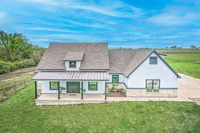 171 Eely Rd, Mcdade, TX 78650 - back of property with stucco siding, a lawn, a standing seam roof, and a shingled roof
