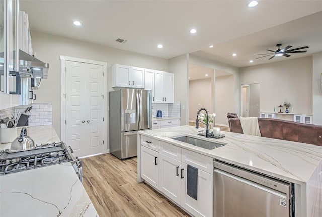 171 Eely Rd, Mcdade, TX 78650 - kitchen with stainless steel appliances, a sink, white cabinetry, light wood-type flooring, and recessed lighting