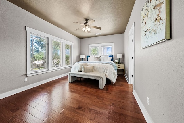 2930 Grand Oaks Loop Unit 401, Cedar Park, TX 78613 - bedroom featuring a textured wall, multiple windows, a textured ceiling, dark wood-style floors, and baseboards