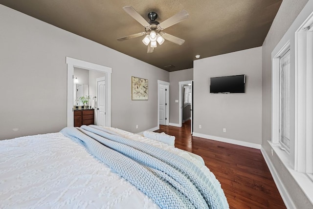 2930 Grand Oaks Loop Unit 401, Cedar Park, TX 78613 - bedroom with dark wood-style flooring, baseboards, ensuite bath, and a ceiling fan