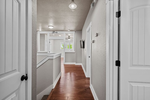2930 Grand Oaks Loop Unit 401, Cedar Park, TX 78613 - corridor with a textured wall, a textured ceiling, dark wood-style floors, and baseboards
