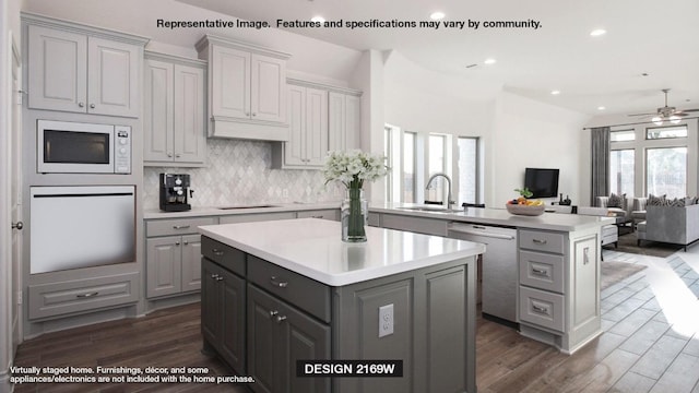 kitchen with oven, a sink, gray cabinetry, dishwasher, and a center island