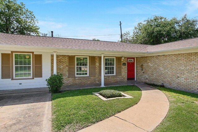 6009 Belfast Dr, Austin, TX 78723 - single story home with brick siding, a front yard, covered porch, and a shingled roof