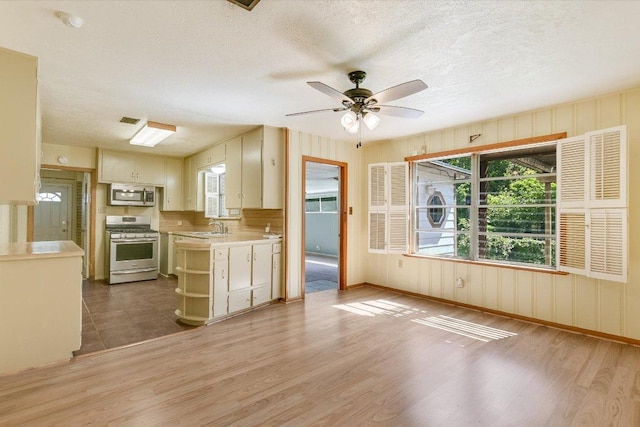 6009 Belfast Dr, Austin, TX 78723 - kitchen featuring appliances with stainless steel finishes, a sink, light countertops, plenty of natural light, and a textured ceiling