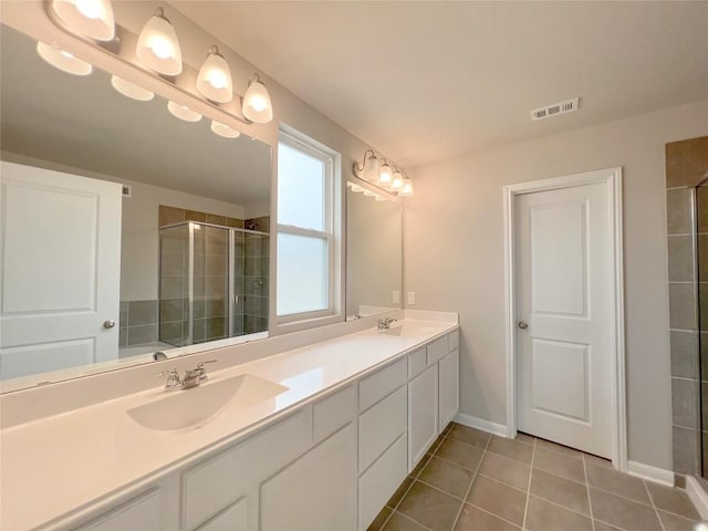 431 Ferrule Dr, Kyle, TX 78640 - bathroom with tile patterned floors, a stall shower, double vanity, and baseboards