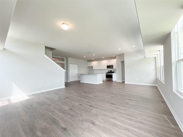431 Ferrule Dr, Kyle, TX 78640 - unfurnished living room with light wood-type flooring, baseboards, and recessed lighting