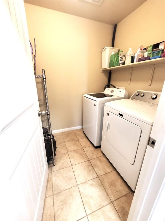 130 Navidad River Dr, Hutto, TX 78634 - laundry area with washing machine and dryer, light tile patterned flooring, and baseboards