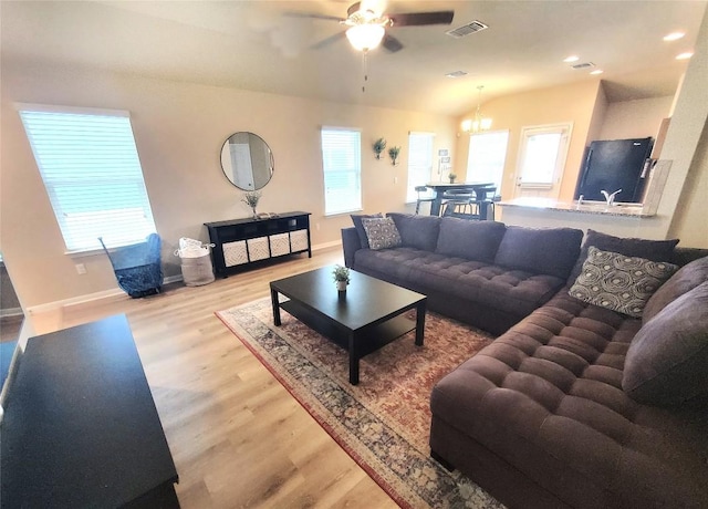 130 Navidad River Dr, Hutto, TX 78634 - living room with a chandelier, light wood-style floors, a ceiling fan, baseboards, and vaulted ceiling