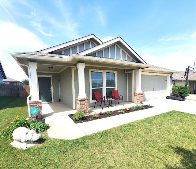 130 Navidad River Dr, Hutto, TX 78634 - view of front of property featuring covered porch, board and batten siding, driveway, an attached garage, and brick siding