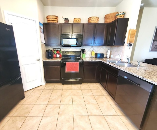 130 Navidad River Dr, Hutto, TX 78634 - kitchen with black appliances, a sink, decorative backsplash, light tile patterned floors, and light stone counters