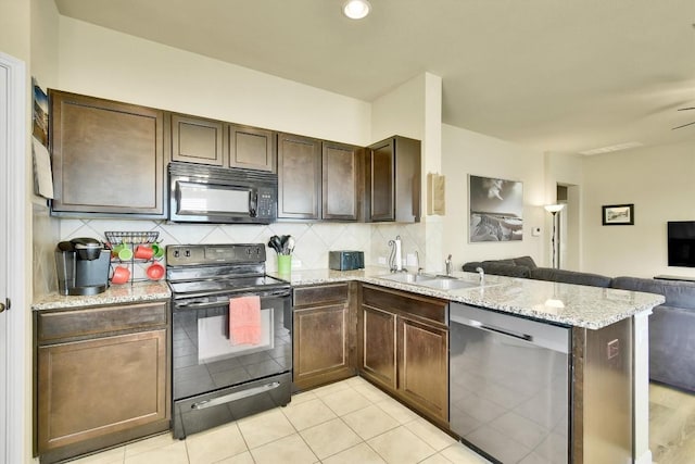 130 Navidad River Dr, Hutto, TX 78634 - kitchen with black appliances, open floor plan, a peninsula, backsplash, and light stone countertops