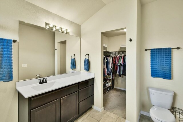 130 Navidad River Dr, Hutto, TX 78634 - bathroom featuring vanity, tile patterned flooring, a walk in closet, and vaulted ceiling