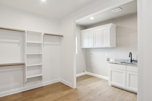 4007 Aerie St, Salado, TX 76571 - washroom with hookup for an electric dryer, light wood-style floors, baseboards, cabinet space, and recessed lighting