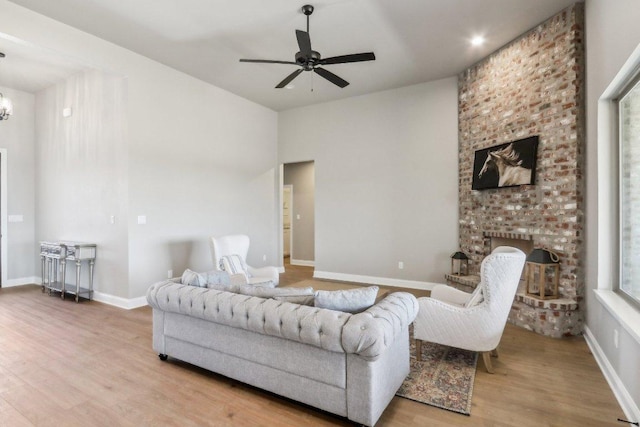 4007 Aerie St, Salado, TX 76571 - living room with wood finished floors, a ceiling fan, a brick fireplace, baseboards, and a chandelier