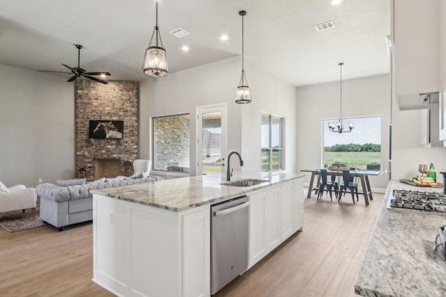 4007 Aerie St, Salado, TX 76571 - kitchen with a sink, stainless steel appliances, light wood-style flooring, white cabinets, and open floor plan