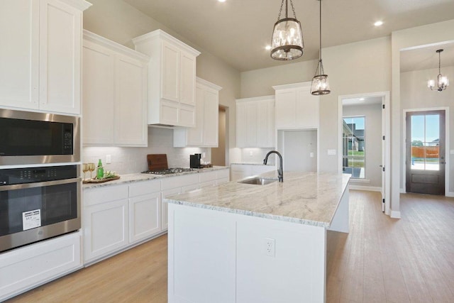 4007 Aerie St, Salado, TX 76571 - kitchen featuring stainless steel appliances, a chandelier, a sink, tasteful backsplash, and white cabinets