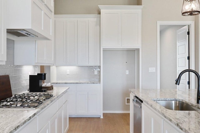 4007 Aerie St, Salado, TX 76571 - kitchen featuring appliances with stainless steel finishes, a sink, white cabinets, light wood finished floors, and backsplash